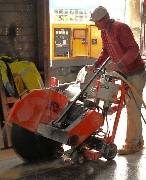 Professionnel effectuant un sciage du sol